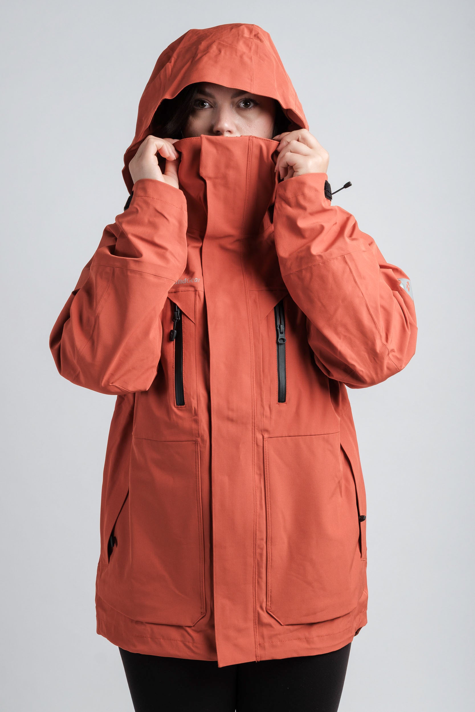 Northbound Gear orange women's Apex waterproof jacket wearer